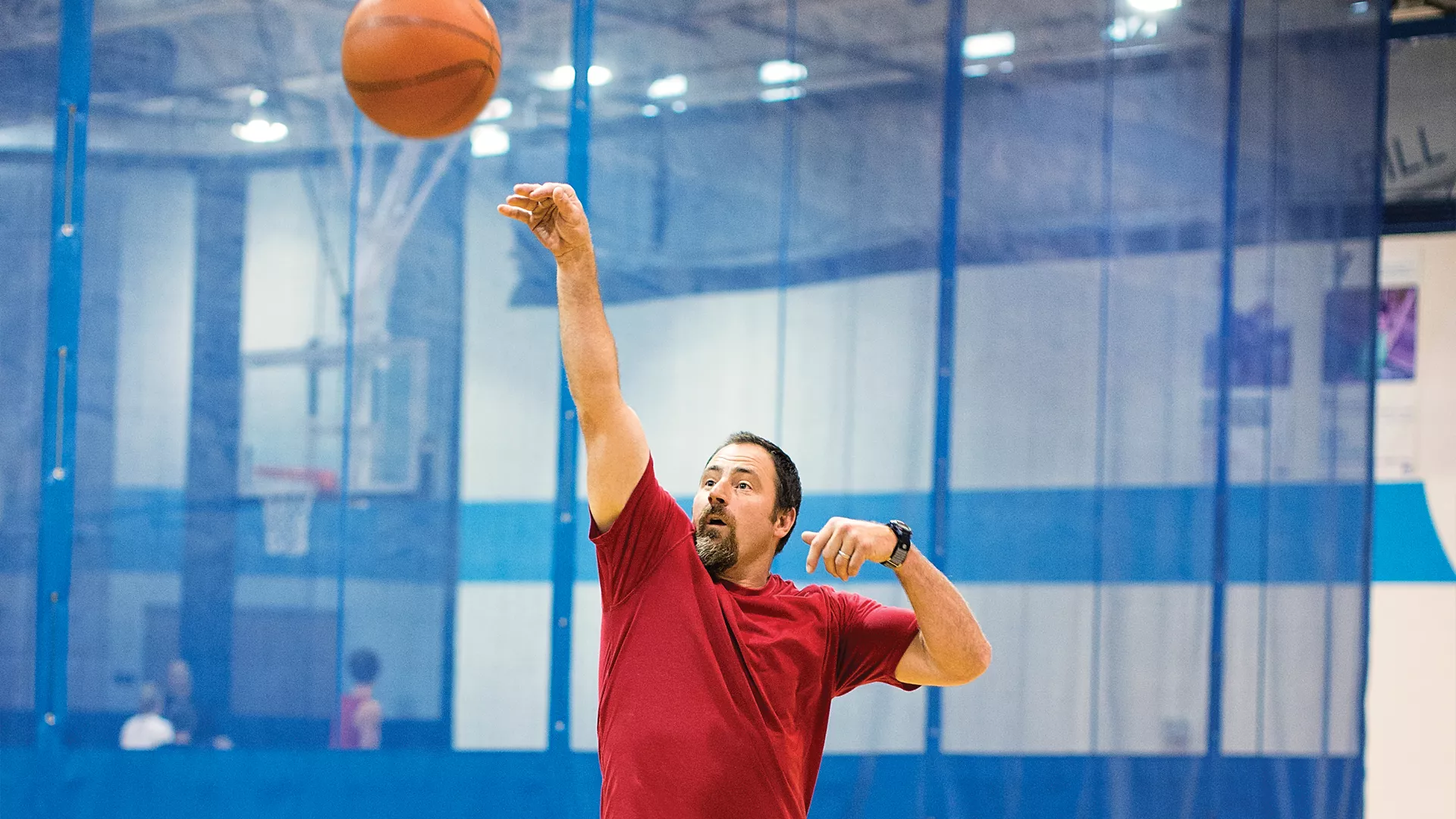 Man shoots a basket during a basketball game.
