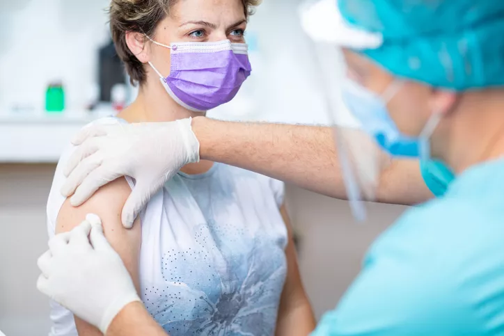 Woman in mask getting prepared for flu shot