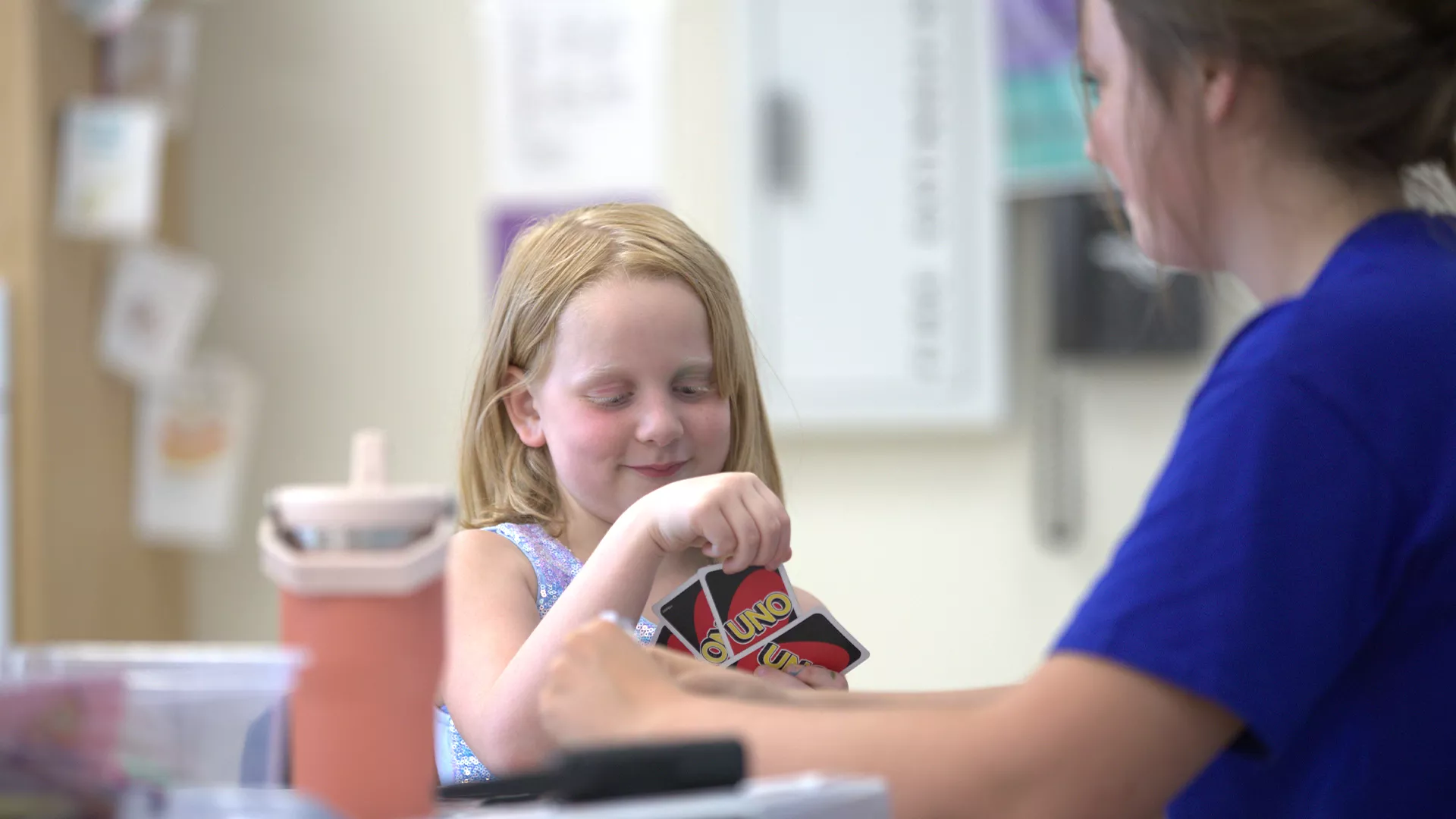 Girl and camp counselor playing UNO 