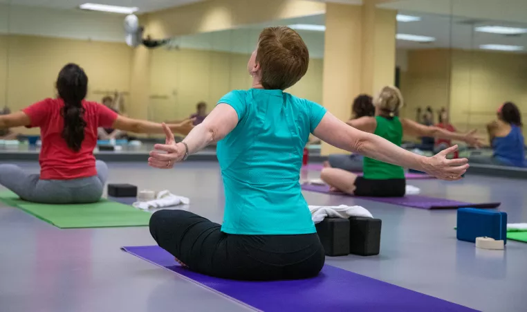 Woman stretches her arms during a yoga class.
