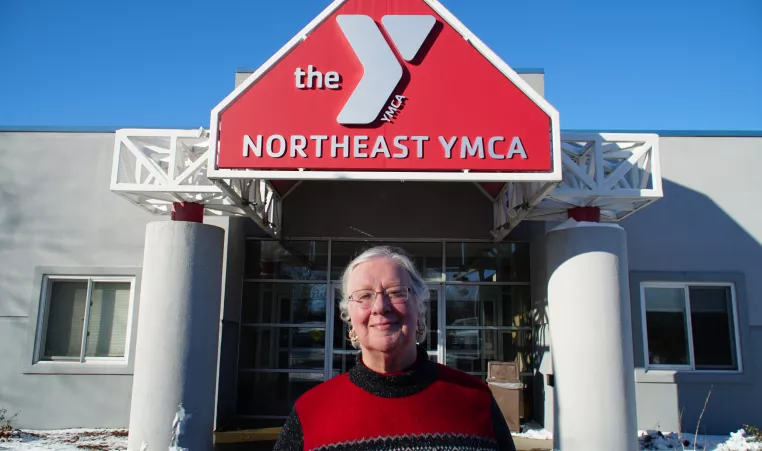 Deb Yost standing in front of the Northeast YMCA