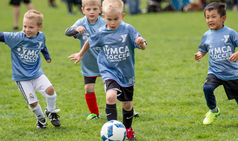 Photo of four kids playing soccer