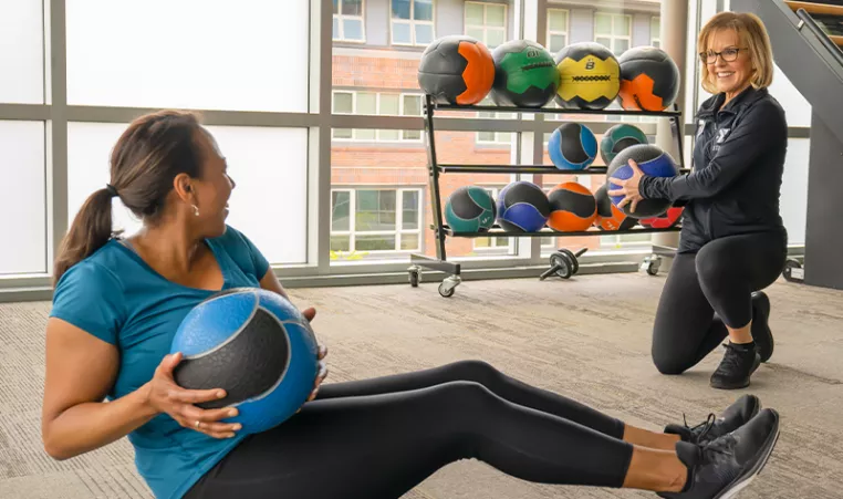 Photo of two women exercising with a medicine ball