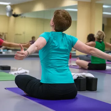 Woman stretches her arms during a yoga class.