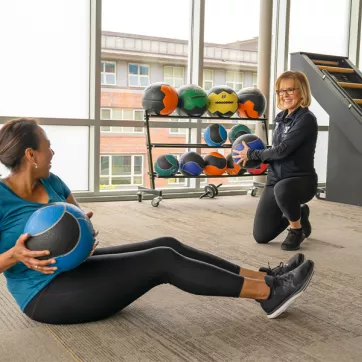 Two women working out together with medicine balls