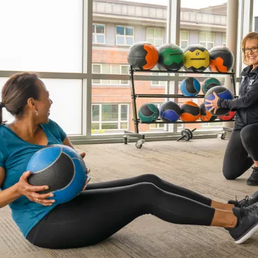 Photo of two women exercising with a medicine ball
